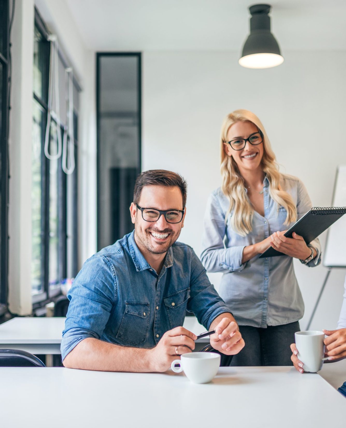 Beautiful casual business people in modern bright office. Looking at camera. Teamwork concept.
