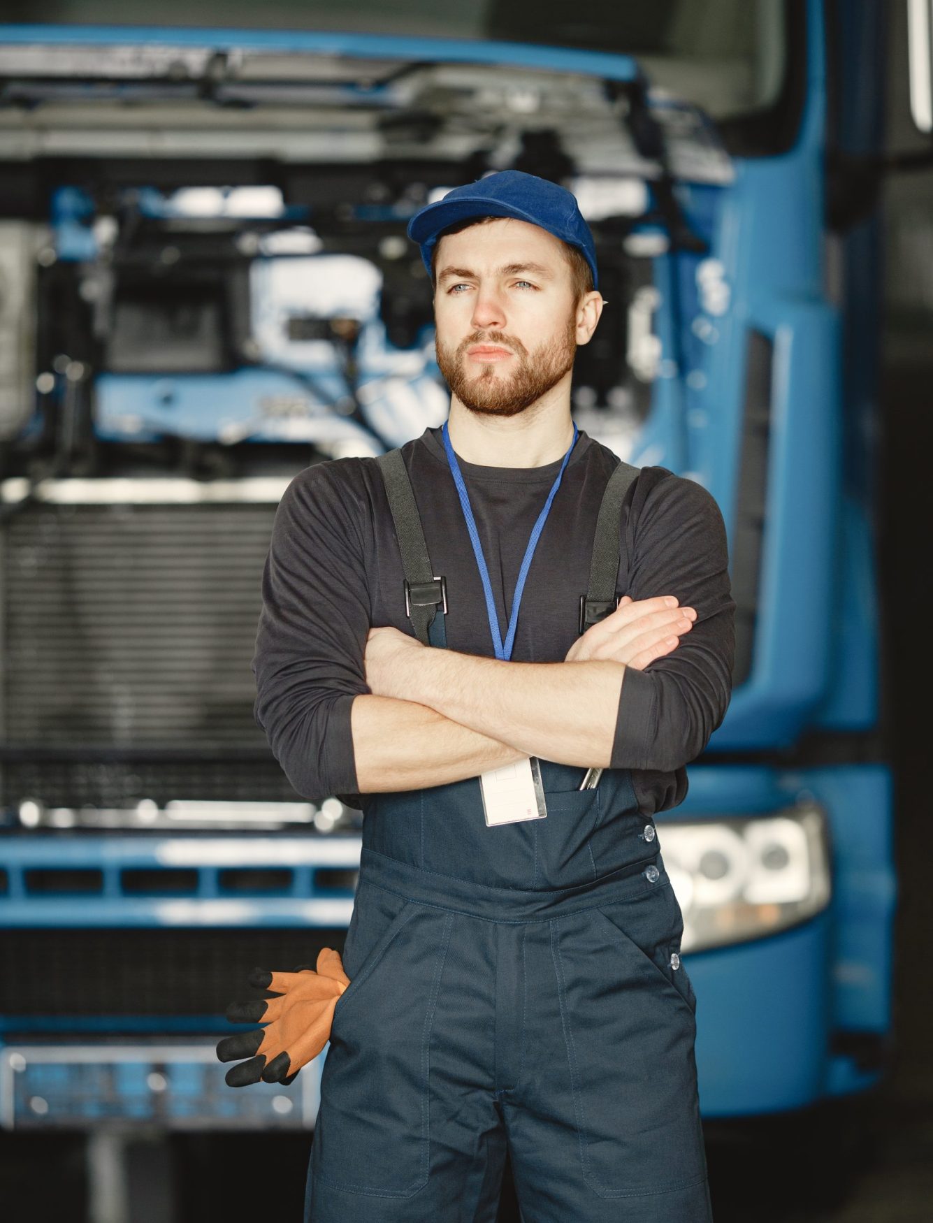 Worker in uniform. Man repairs a truck. Man with tools
